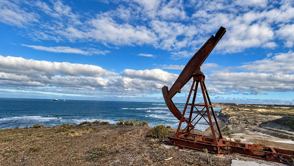 Restos oxidados de un aparato de bombeo en lo alto de un cerro, frente al mar, en la entrada de Caleta Córdova